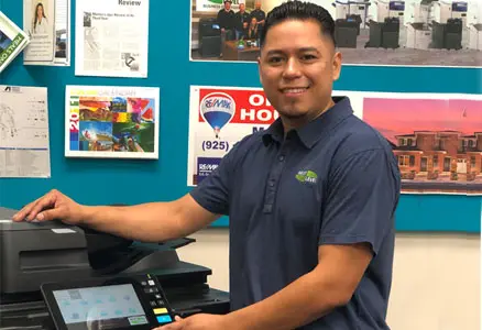 Factory-trained Next Level technician servicing an office copier on-site